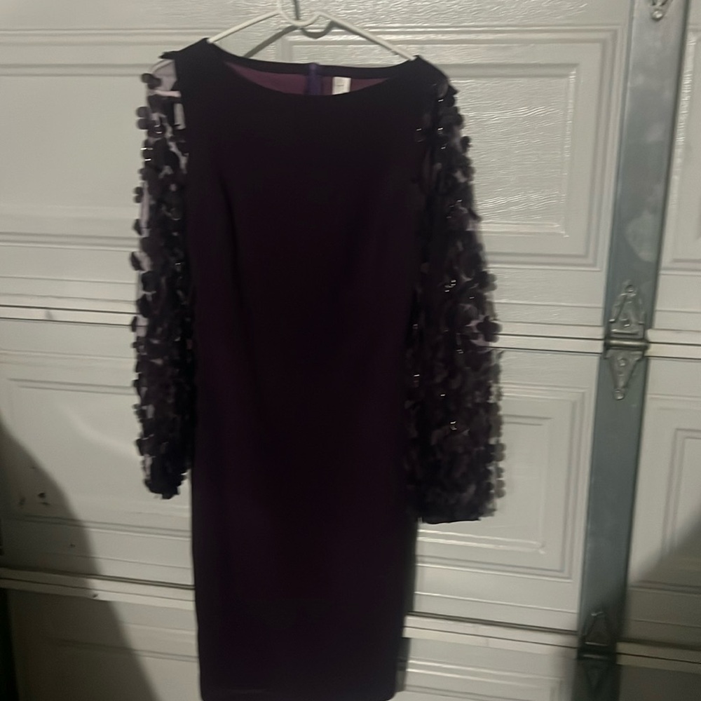Es un lindo vestido color morado talla M con mangas largas con flores no usado